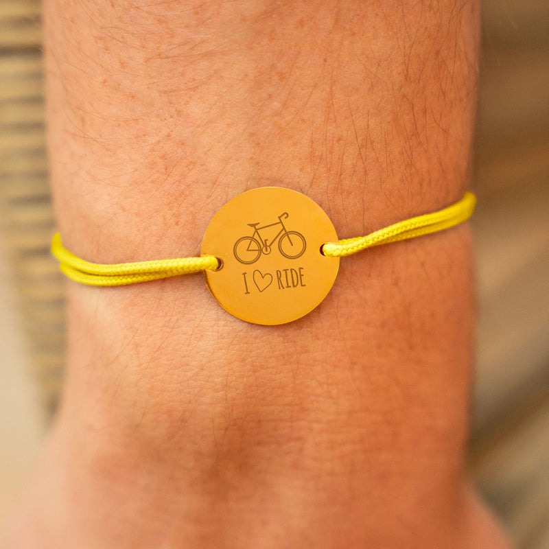 Le bracelet parfait pour les amateurs de vélo ! Médaille plaqué or, cordon jaune : personnalisez-le pour porter vos passions et vos souvenirs à votre poignet.