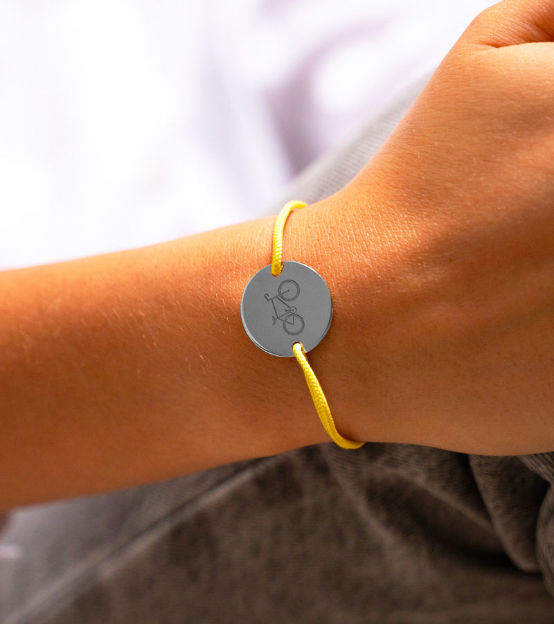 Le raffinement de l'argent avec une touche de peps ! Ce bracelet, médaille en argent et cordon jaune, allie élégance et modernité. Personnalisez-le pour en faire un accessoire unique.