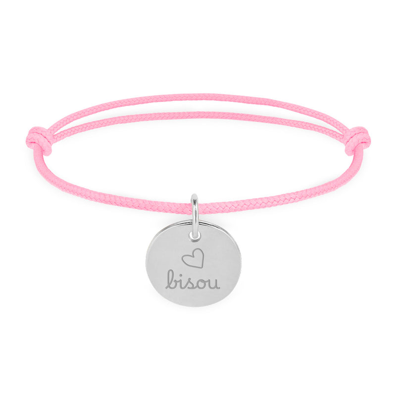 Un bracelet argenté avec une médaille de 15mm et un cordon rose.