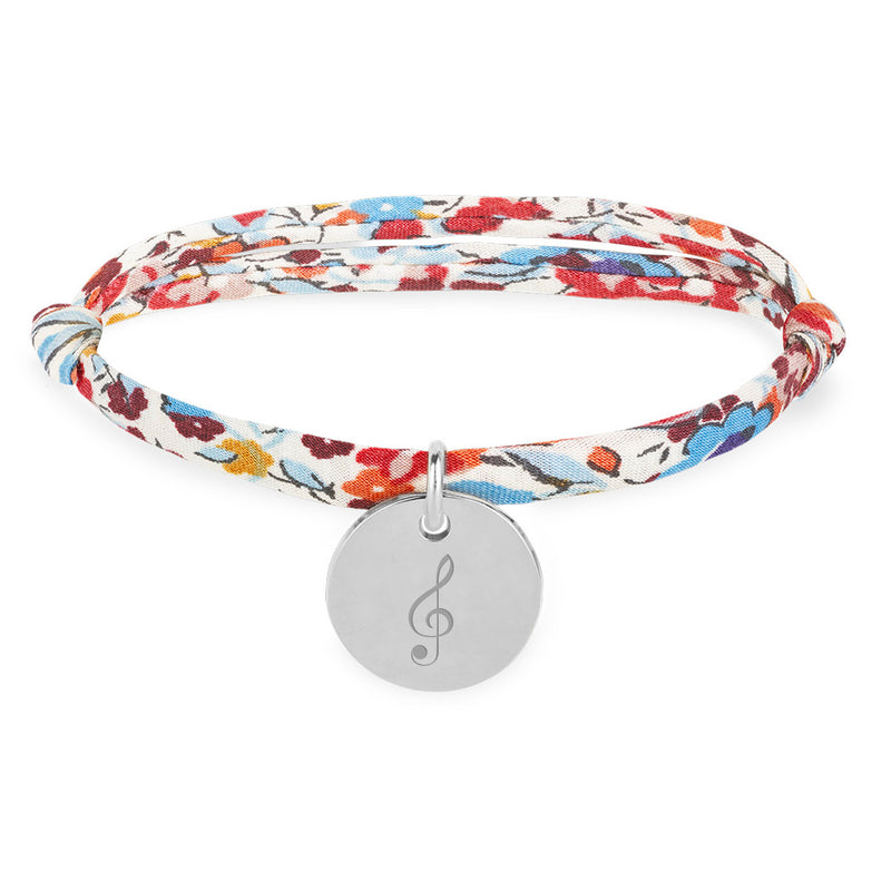 Bracelet argenté orné d'une médaille de 15mm, lié à un Liberty Pavot.