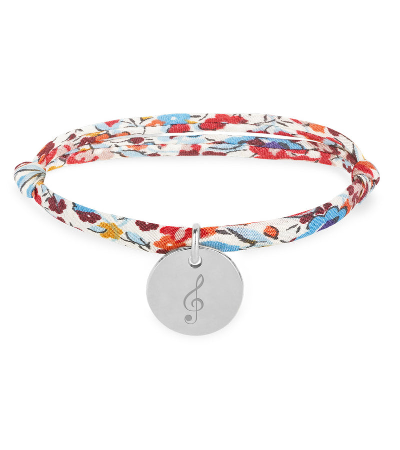 Bracelet argenté orné d'une médaille de 15mm, lié à un Liberty Pavot.