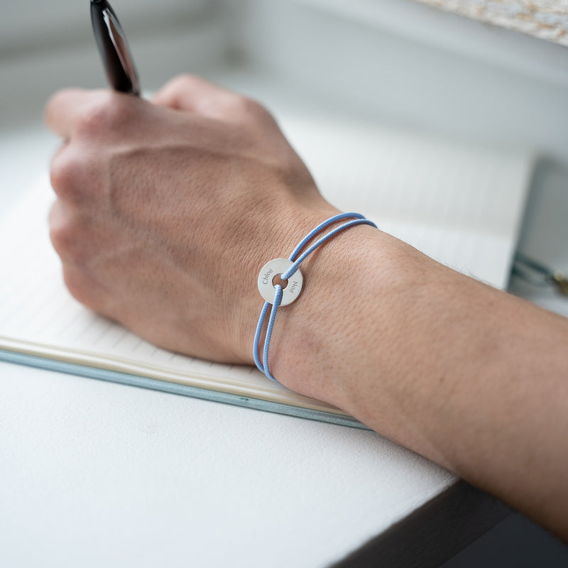 Un bracelet en forme de cible, personnalisé de 15mm en argent, avec un cordon bleu pastel.