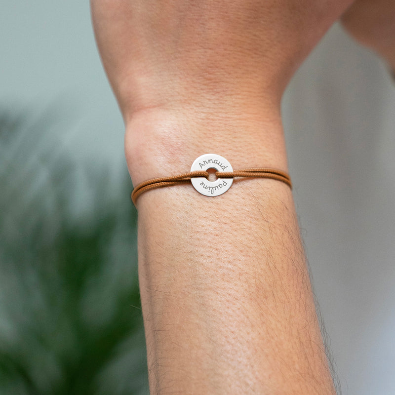 Le cordon marron clair met en valeur ce bracelet en forme de cible, personnalisé de 15mm en argent.