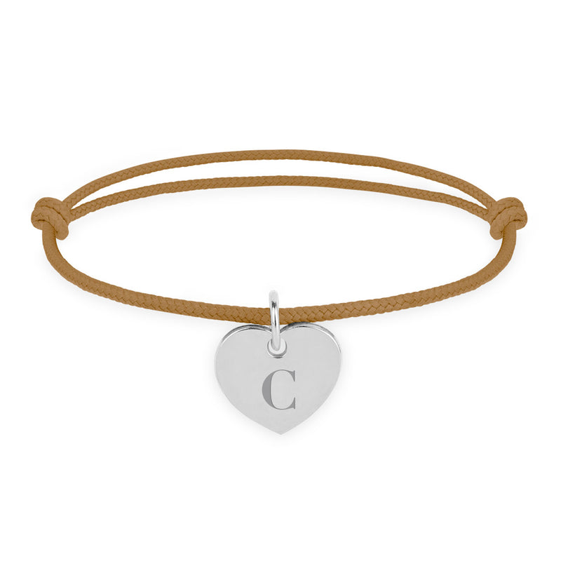 Une photo montrant un bracelet personnalisé en forme de cœur, d'un diamètre de 15mm, en argent, avec un cordon marron clair.