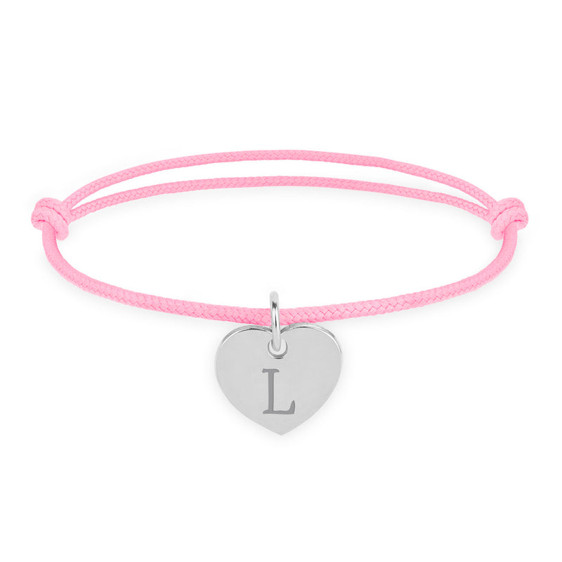 Le bracelet présente un cœur argenté de 15mm, monté sur un cordon rose.