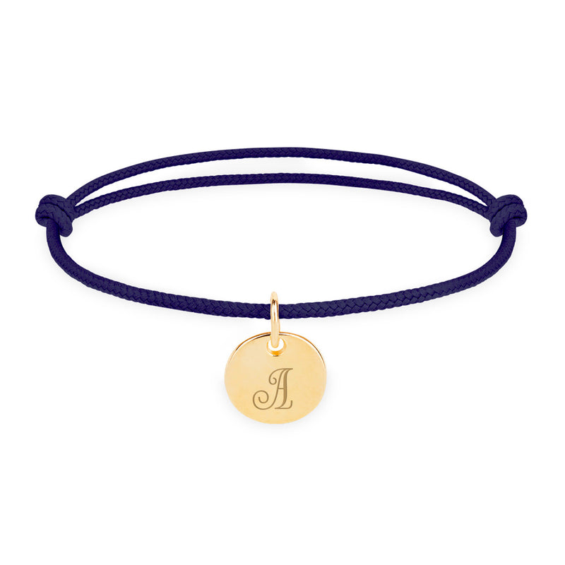 Un magnifique bijou avec une médaille 10mm plaquée or, sur un élégant cordon bleu marine.