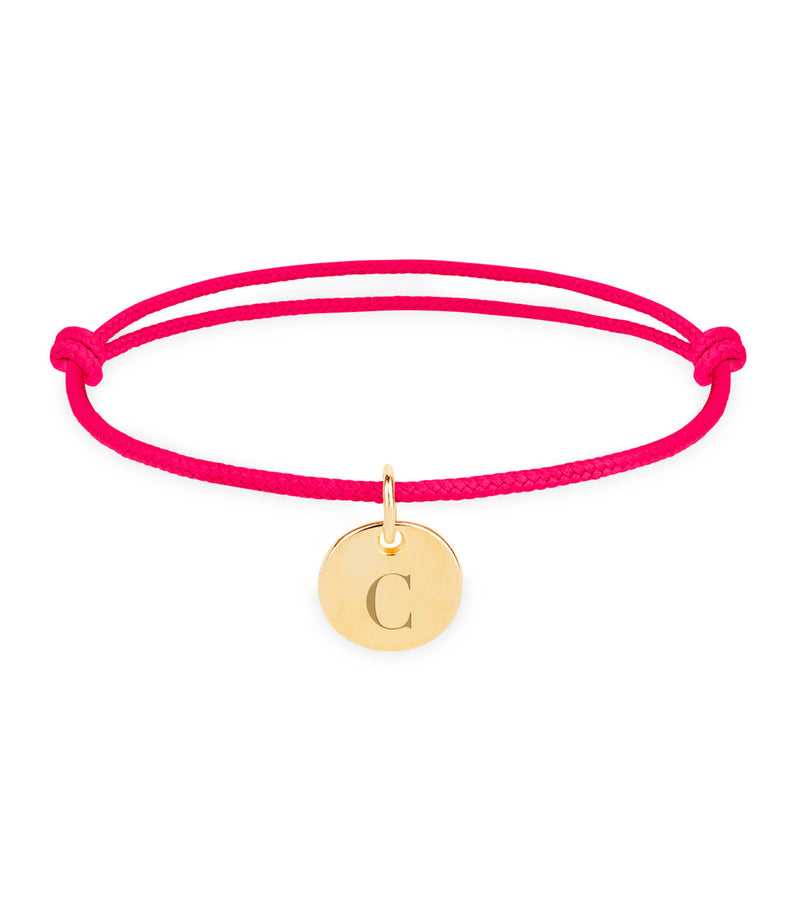 Un bijou délicat composé d'un cordon rose fuchsia et d'une médaille en or plaqué de 10mm.
