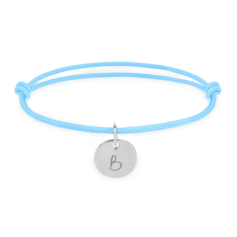 Un bracelet personnalisé, avec une médaille de 10mm en argent sur un cordon bleu pastel.
