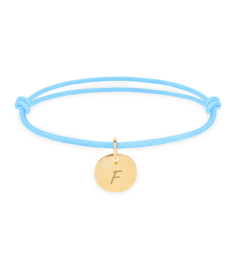 Un bracelet personnalisé en plaqué or, avec une médaille de 10mm, sur un cordon bleu pastel.