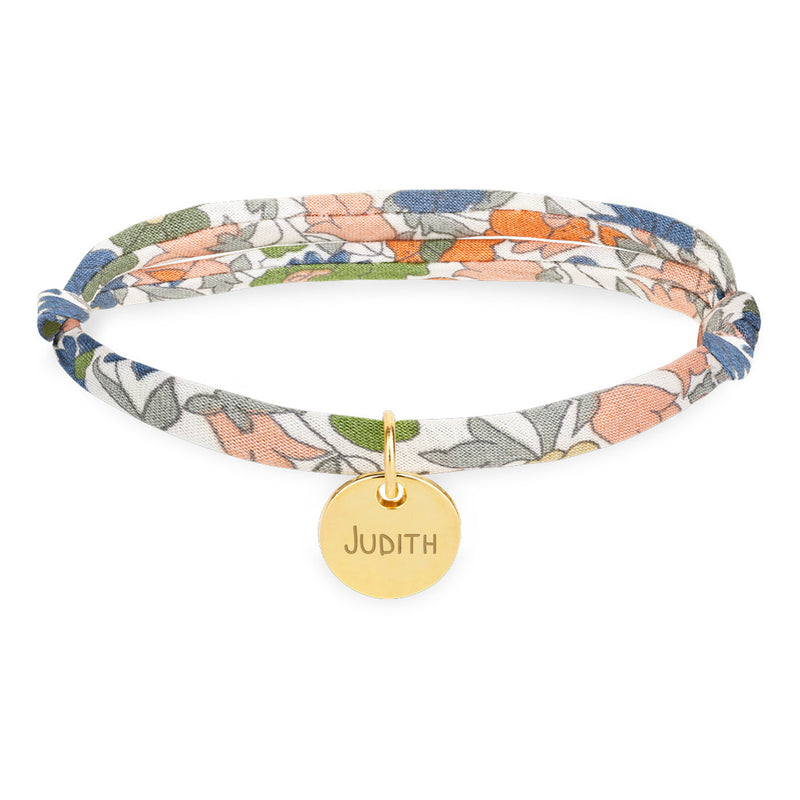 Un bracelet personnalisé avec une médaille de 10mm en plaqué or, agrémenté d'un lien Liberty lilas.