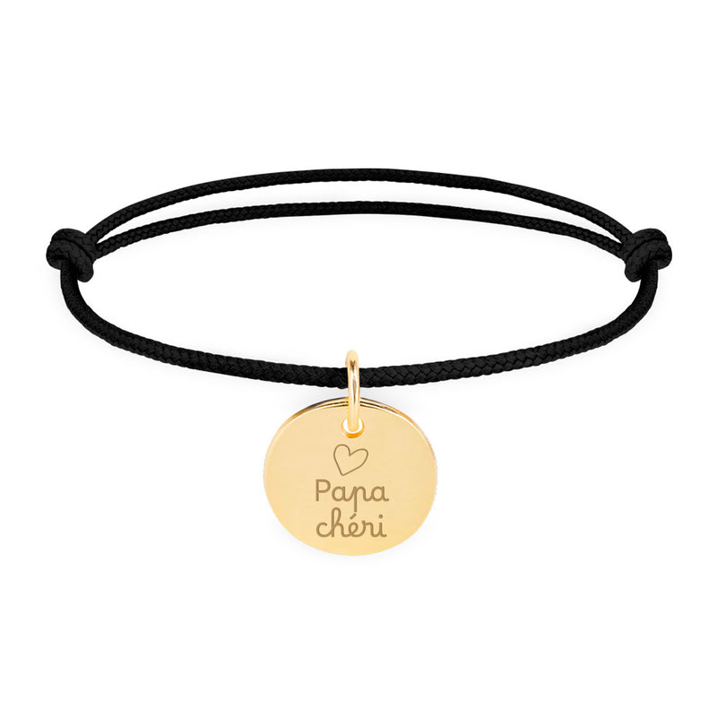 Un bracelet personnalisé en plaqué or, avec une médaille de 15mm, sur cordon noir.