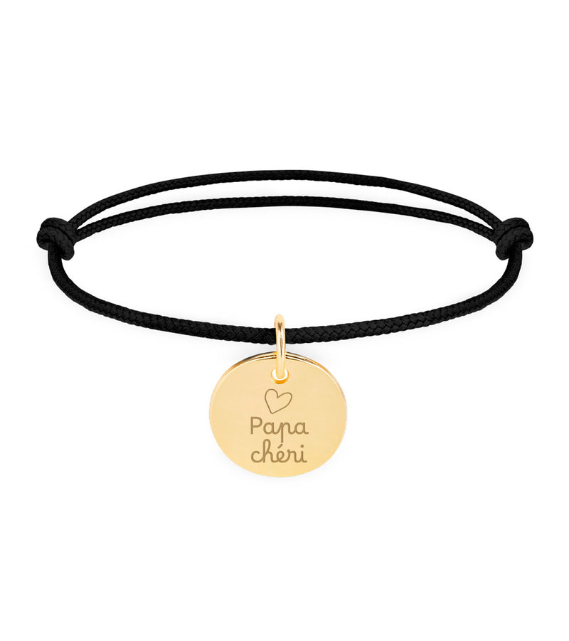Un bracelet personnalisé en plaqué or, avec une médaille de 15mm, sur cordon noir.