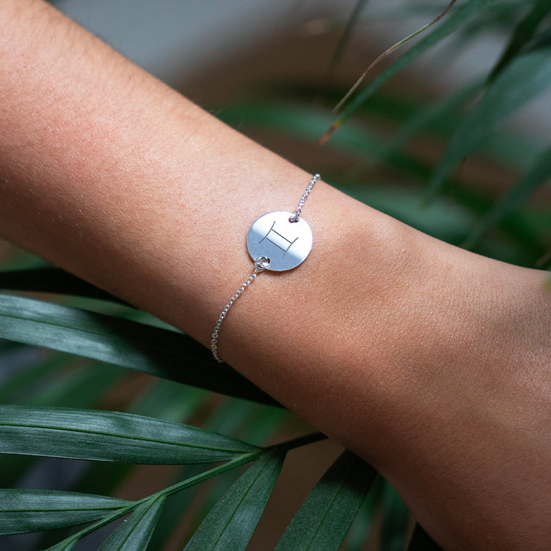 Un bracelet en argent orné d'une médaille personnalisée de 15mm, montée sur une chaîne à maille délicate. L'ajustement à deux trous permet d'ajuster.
