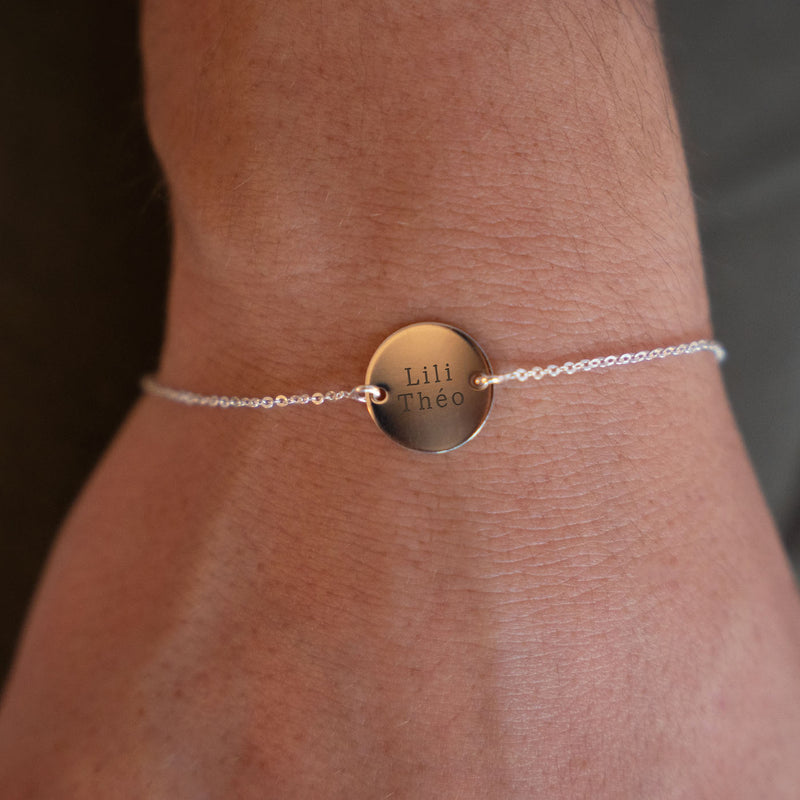 Une médaille de 15mm personnalisée, montée sur un bracelet en argent, dont la chaîne plate assure un ajustement confortable ainsi qu'une fixation avec ses deux trous.