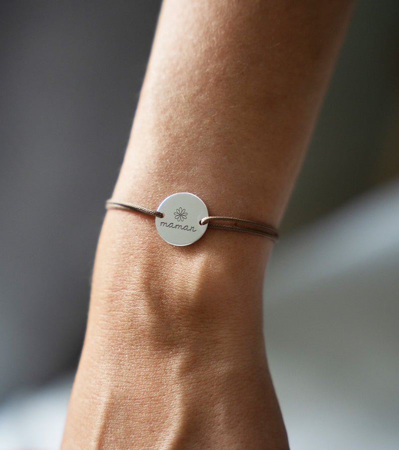 Bracelet argenté doté d'une médaille de 15mm personnalisée à deux trous et d'un cordon marron clair.