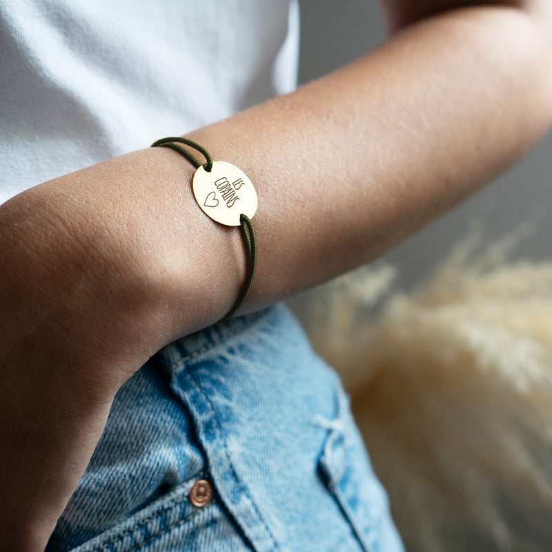 un bracelet médaille, personnalisé en 20mm, orné de deux trous en plaqué or et accompagné d'un cordon kaki.