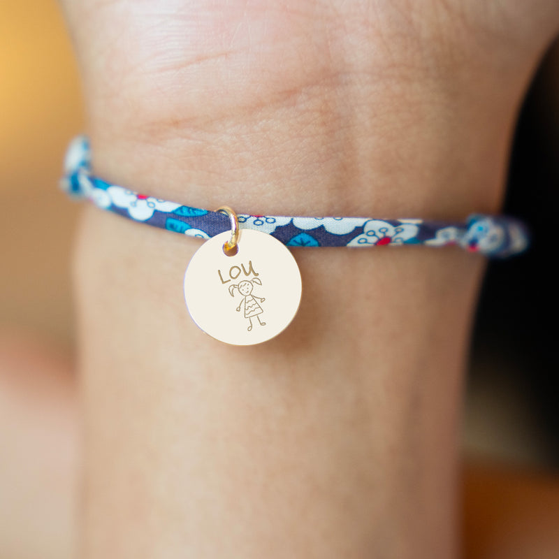 Superbe bracelet agrémenté d'une médaille plaquée or de 15mm, reliée par un lien en Liberty Iris.