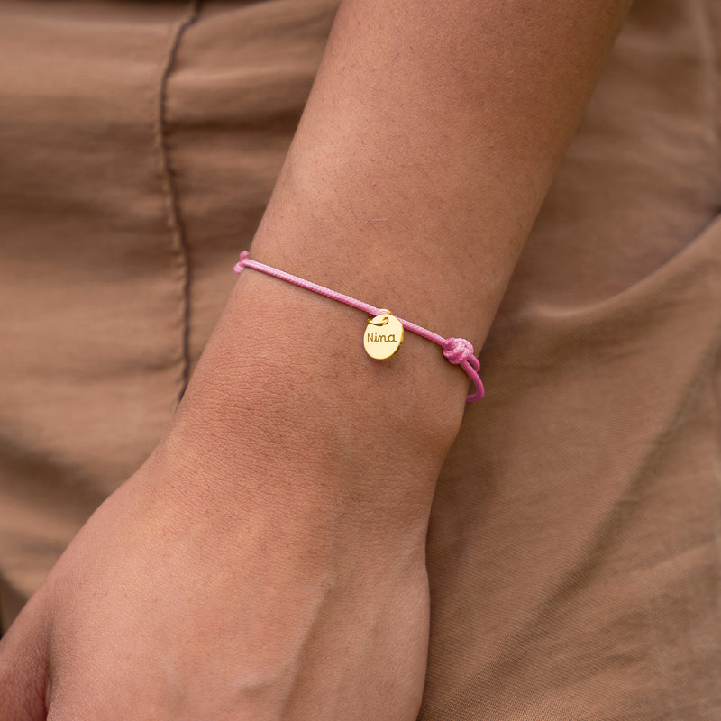 Bracelet personnalisé médaille plaqué or, cordon rose. Exprimez votre style avec cet accessoire unique.