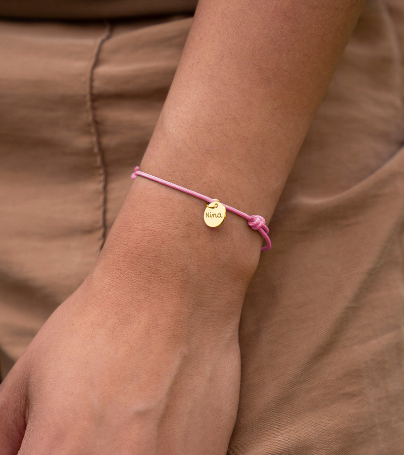 Bracelet personnalisé médaille plaqué or, cordon rose. Exprimez votre style avec cet accessoire unique.