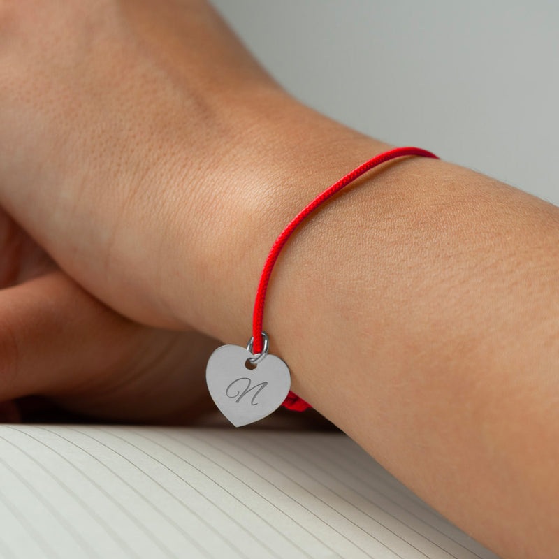 Bracelet argenté en cœur avec cordon rouge pour une touche d'élégance.