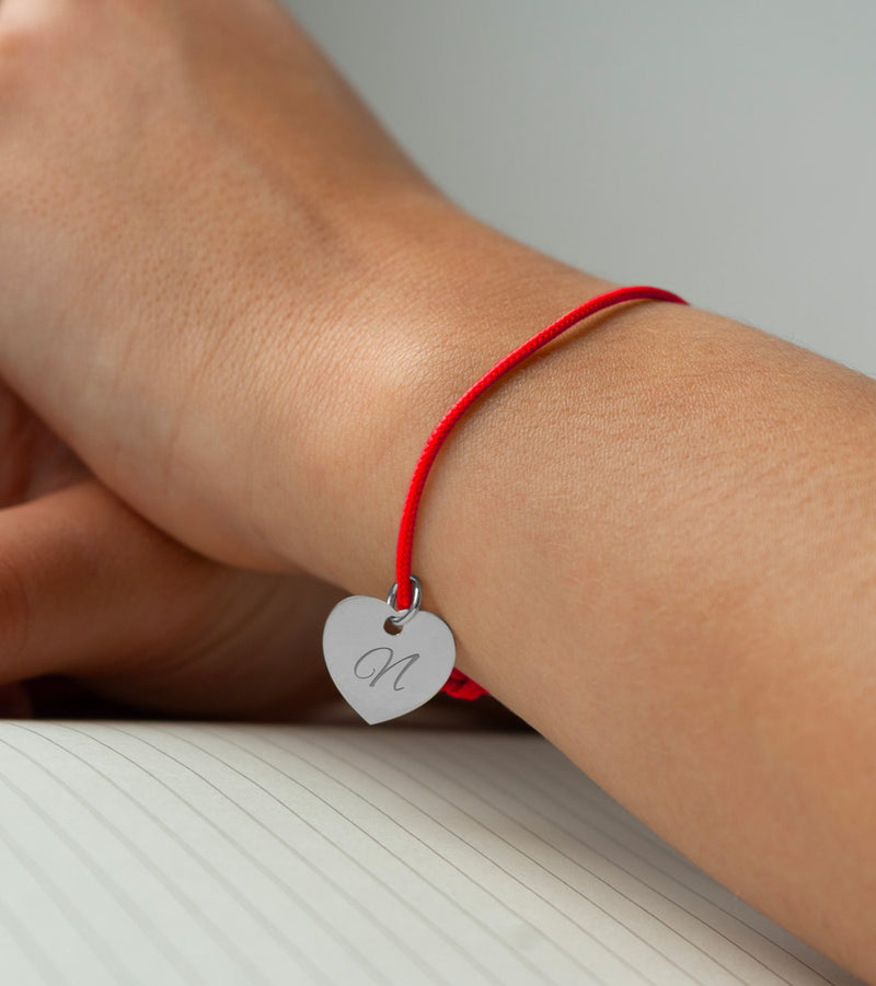 Bracelet argenté en cœur avec cordon rouge pour une touche d'élégance.