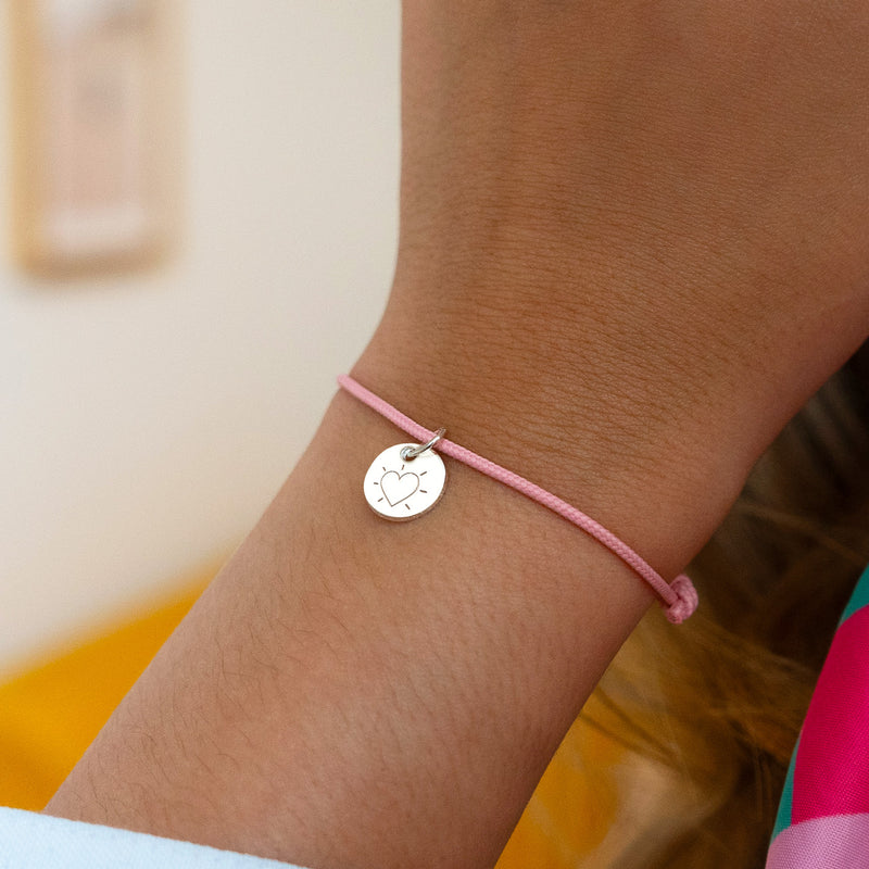 Bracelet argenté avec médaille de 10mm sur cordon rose. Un accessoire charmant.
