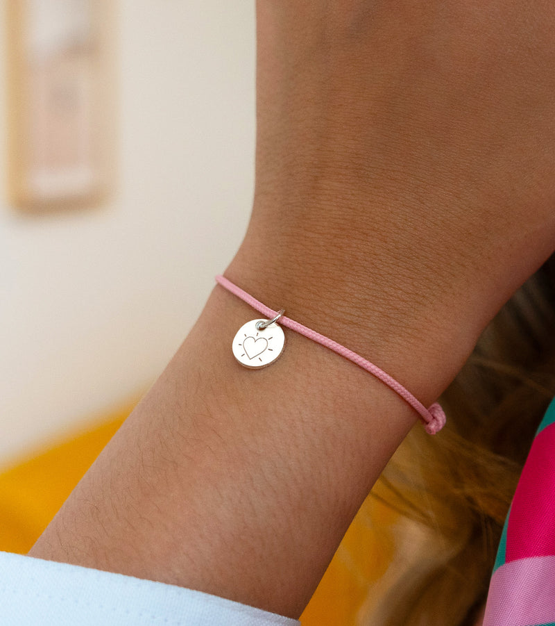 Bracelet argenté avec médaille de 10mm sur cordon rose. Un accessoire charmant.