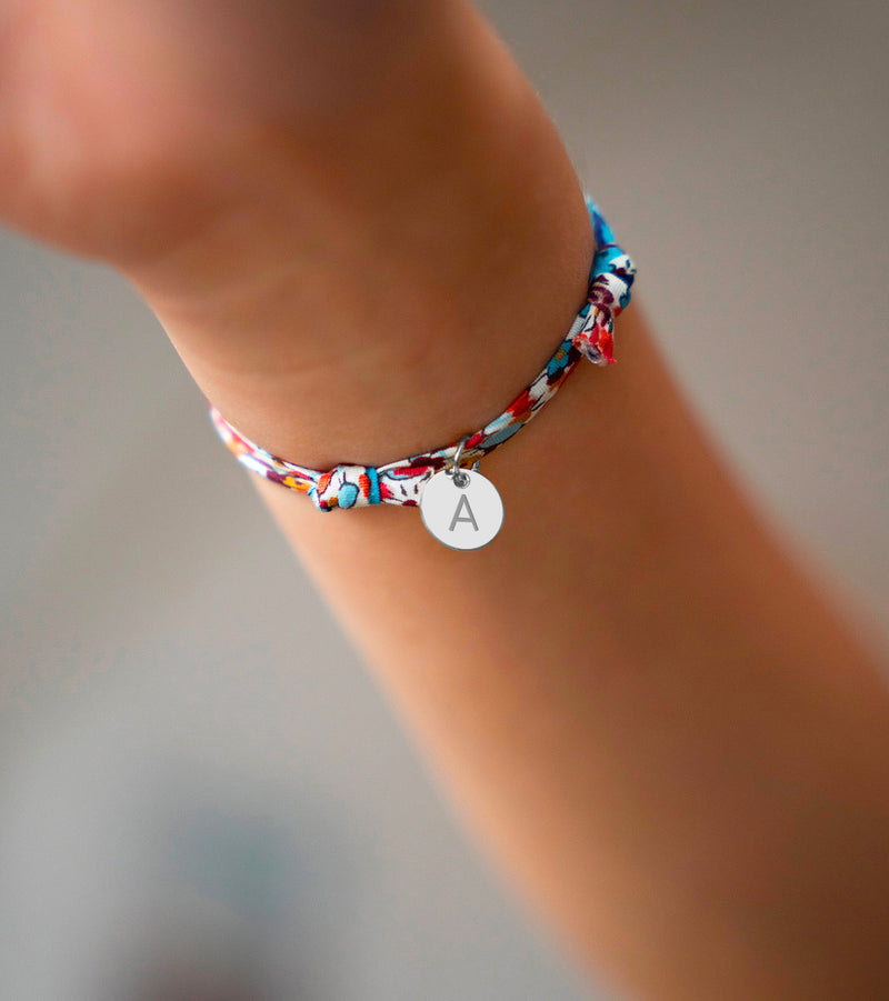 Un bracelet en argent avec une médaille de 10mm, rehaussé par un motif Liberty Pavot.