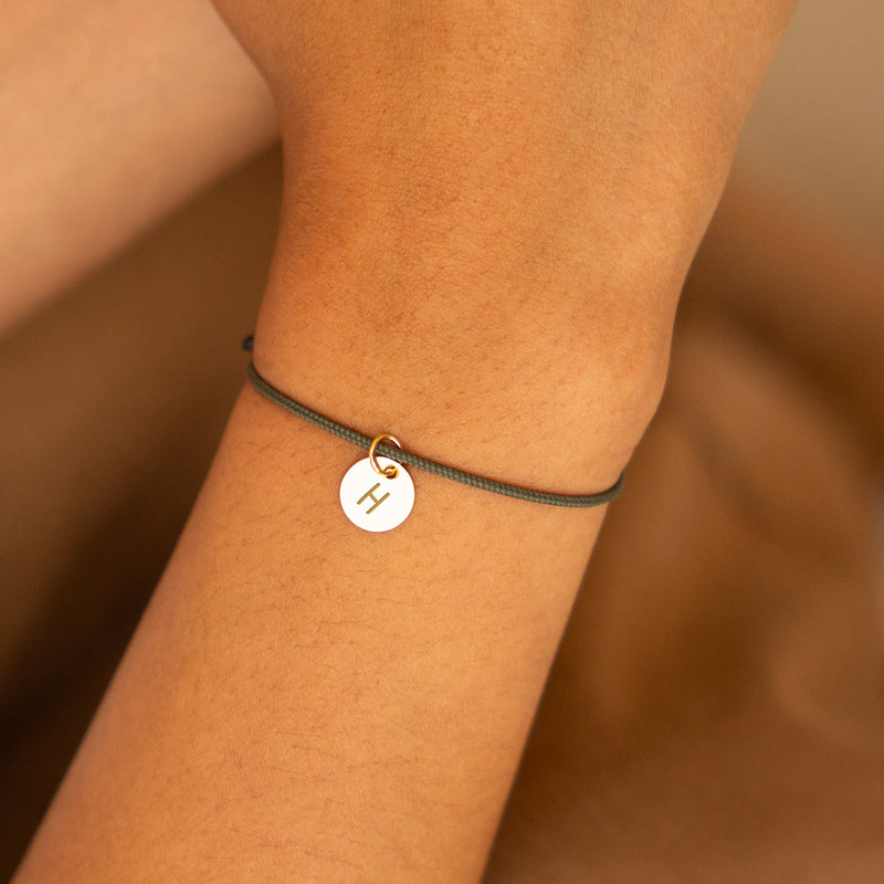 Médaille plaquée or de 10mm sur un bracelet en cordon kaki, gravée selon vos souhaits.