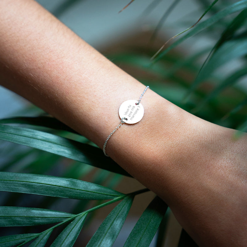 Un bracelet argenté à maille fine, orné d'une médaille personnalisée de 15mm accompagné de deux trous.