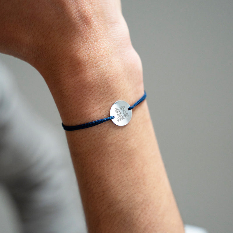 La finesse de l'argent avec une médaille personnalisée de 15mm, sur un bracelet agrémenté d'un cordon bleu marine.