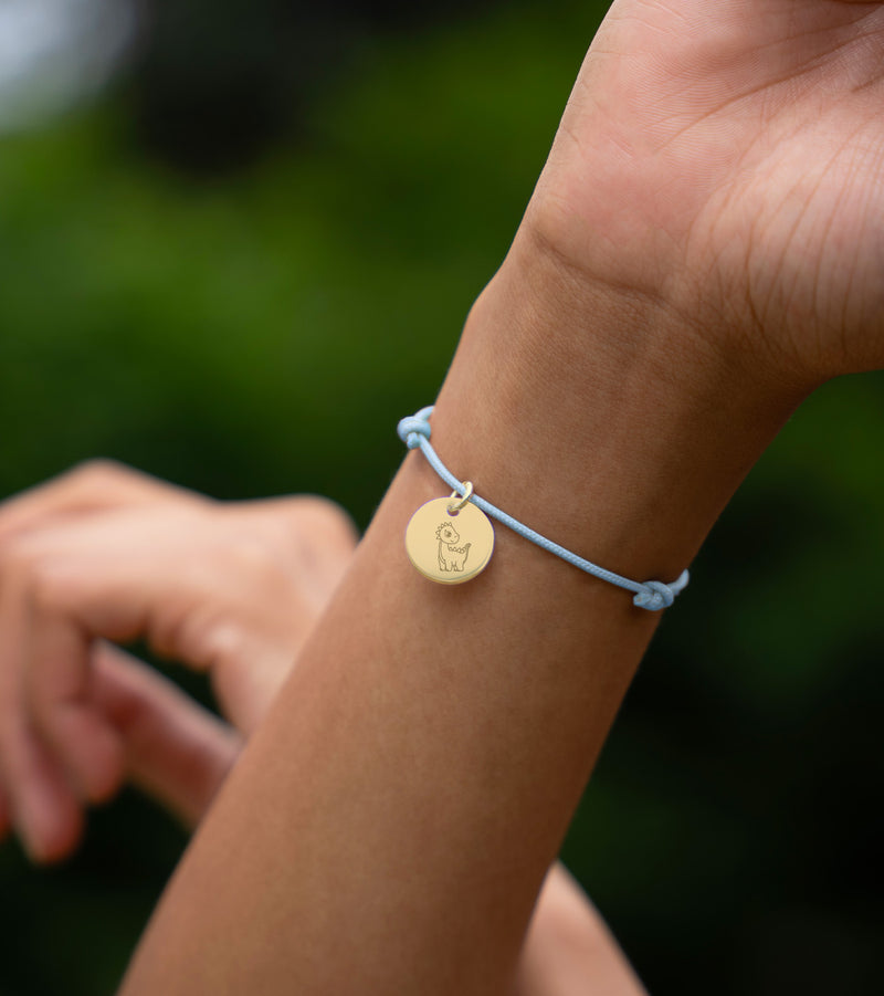 Distinguez-vous avec ce bracelet en cordon bleu pastel, agrémenté d'une médaille plaquée or de 15mm, pour une allure chic et tendance.