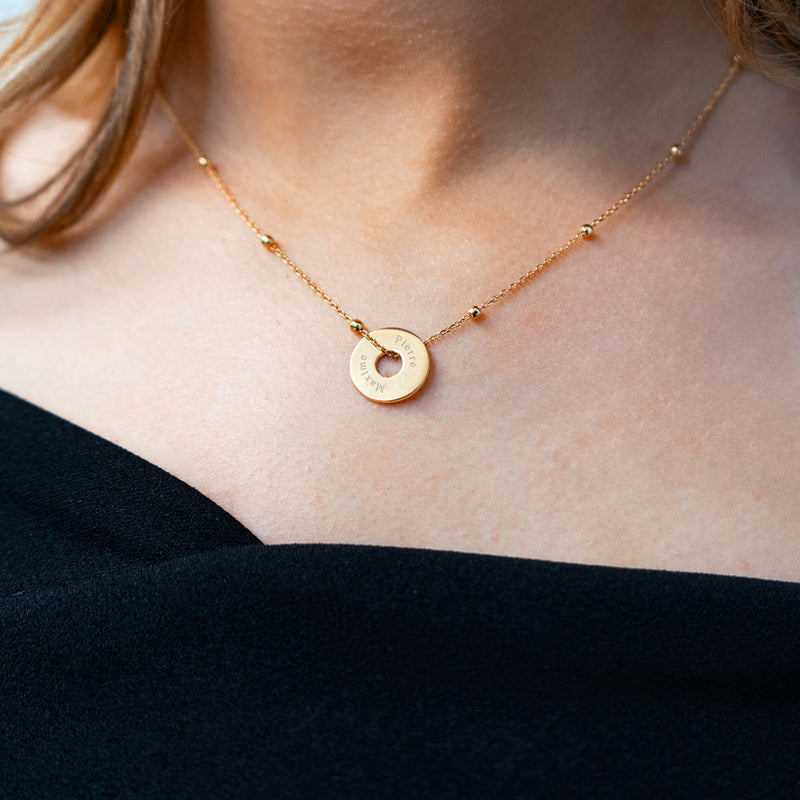 Un pendentif personnalisé, en forme de cible, de 15mm en plaqué or, évoque l'élégance.