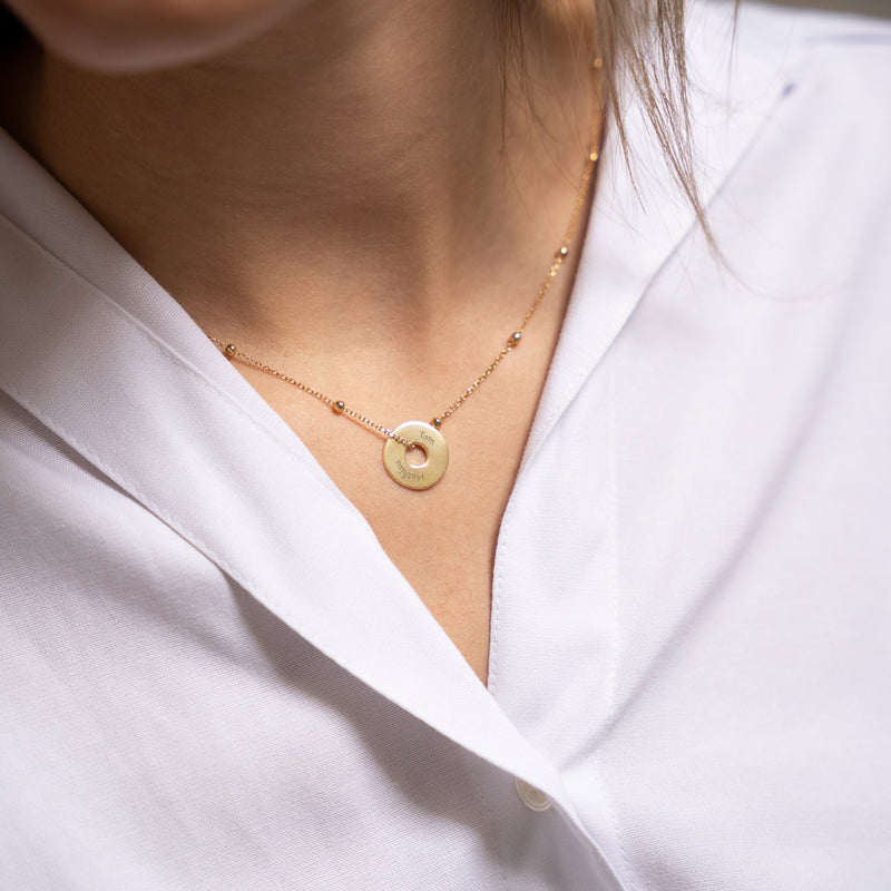 Arborer un pendentif de 15mm en plaqué or, personnalisé en forme de cible, symbolise le raffinement.