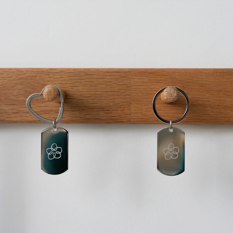 En acier inoxydable, ce porte-clé rectangle 39mm x 22mm s'embellit d'un anneau rond de 30mm