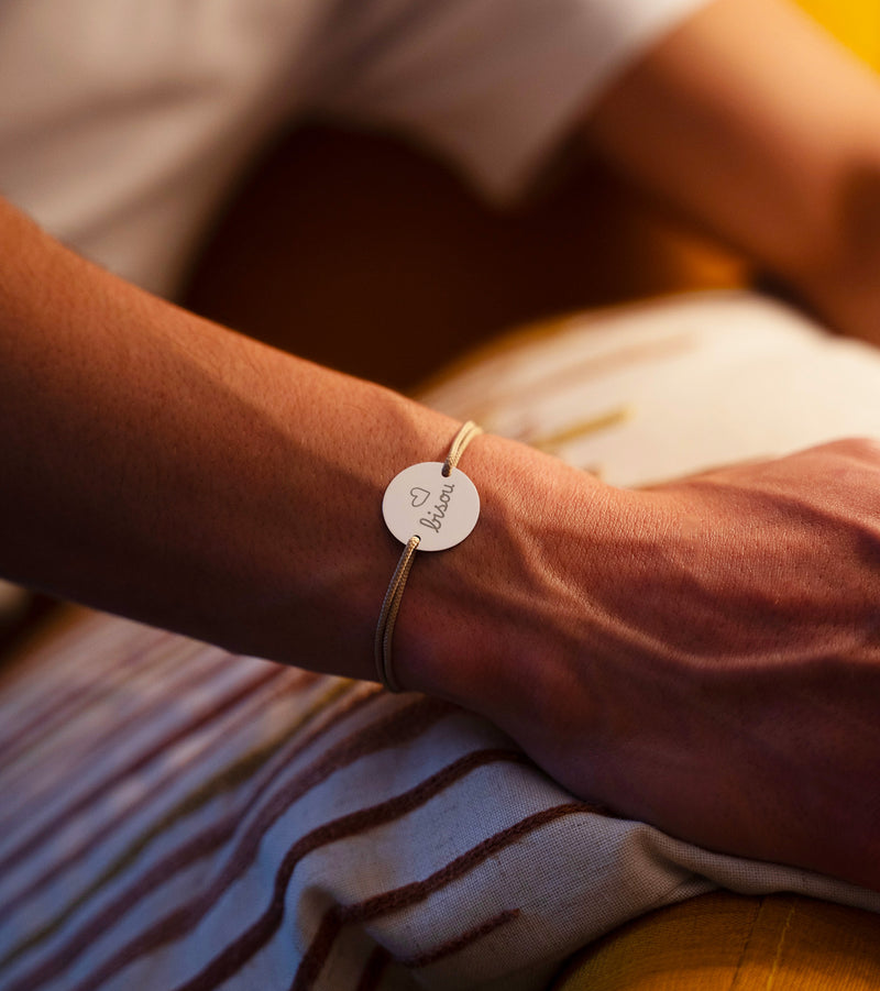 Optez pour l'originalité avec ce bracelet médaille 20mm personnalisé, cordon beige, et deux trous en argent.