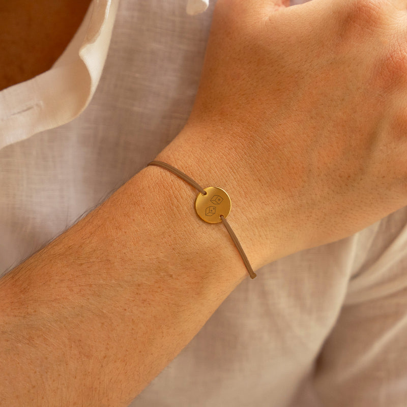 bracelet personnalisé, avec une médaille plaquée or de 15mm et deux trous, agrémenté d'un cordon marron clair.
