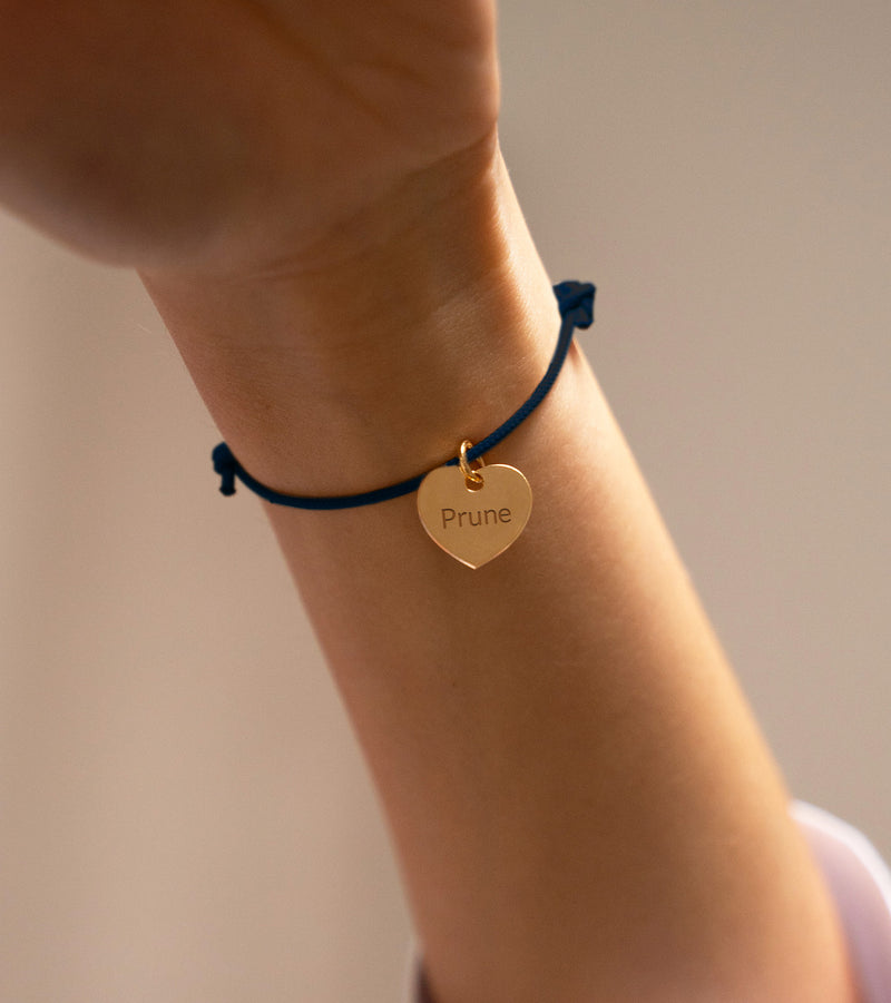 Un bracelet avec un cordon en bleu marine et un cœur en plaqué or 15mm.