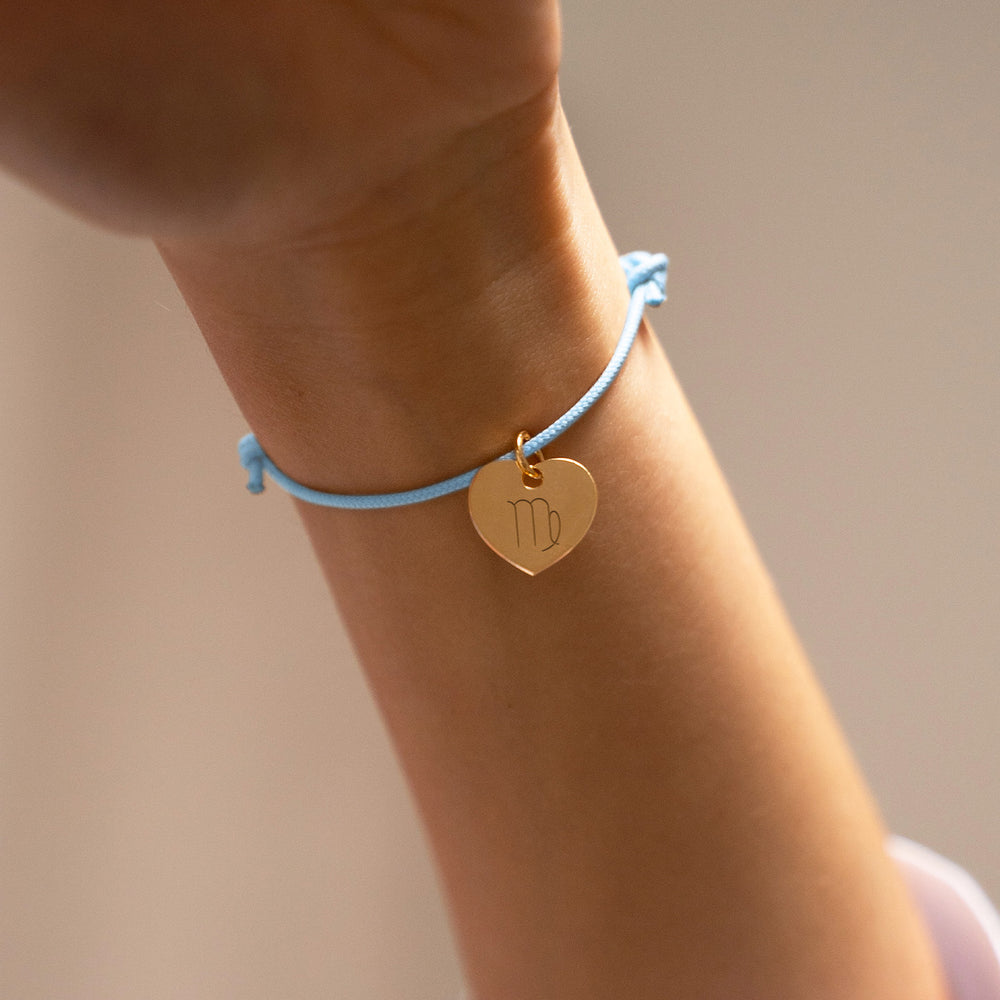 Un magnifique bracelet personnalisé, mettant en valeur un charmant cœur doré de 15mm, sur un cordon en bleu pastel, symbole de tendresse et d'affection.