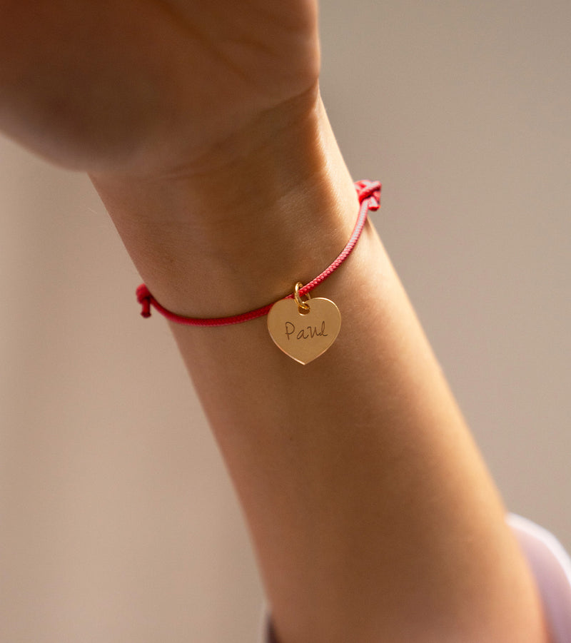  Bracelet personnalisé en cordon rouge met en valeur un délicat cœur plaqué or de 15mm.