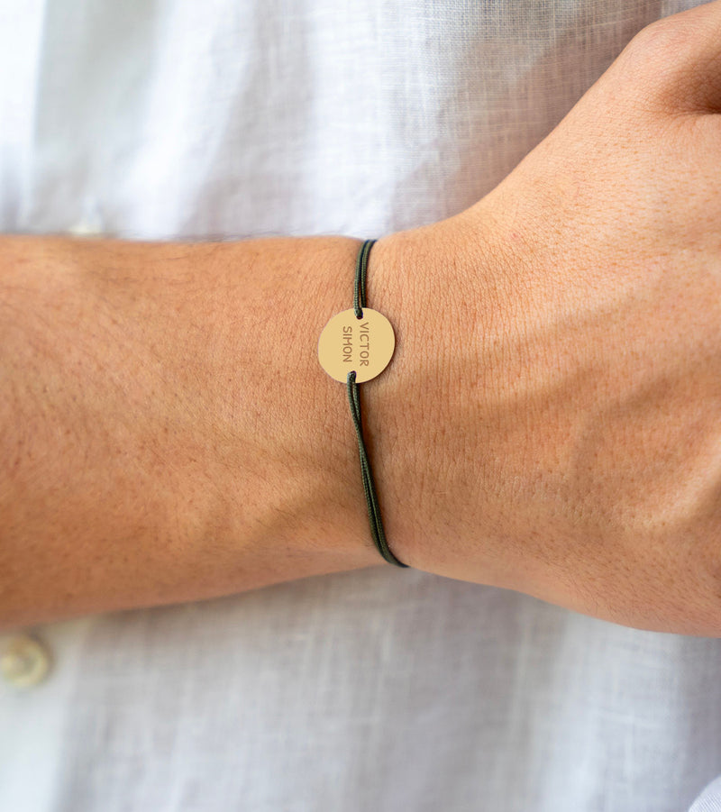 Un bracelet personnalisé en plaqué or, orné d'une médaille de 15mm à deux trous, captivant avec son cordon kaki