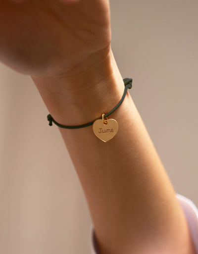 Un bracelet plaqué or, orné d'un cœur de 15mm, personnalisé sur un cordon kaki.