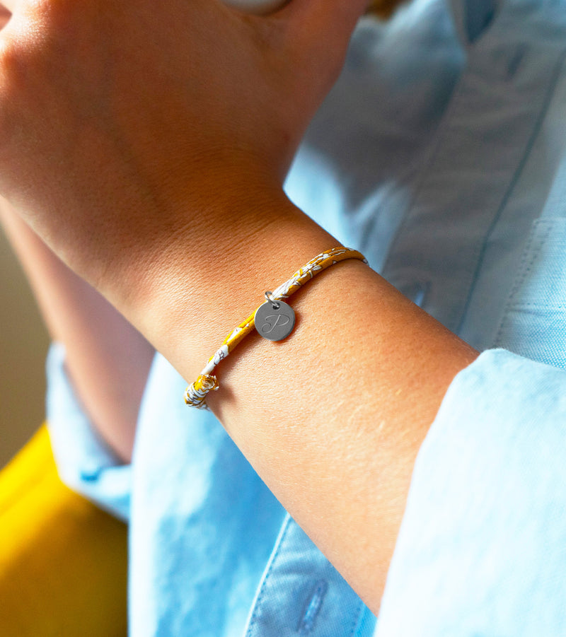 Médaille argentée de 10mm sur un bracelet personnalisé avec un lien liberty Clivia, un accessoire raffiné et moderne.