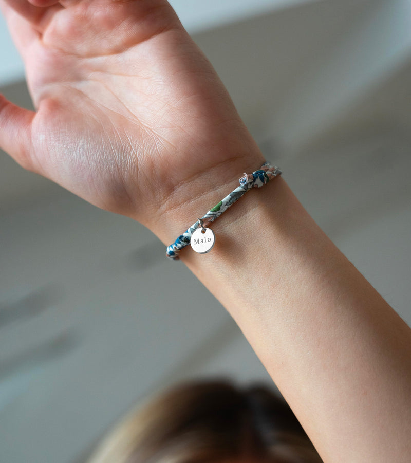 Un bracelet en argent, agrémenté d'une médaille de 10mm et d'un charmant Liberty Lilas.
