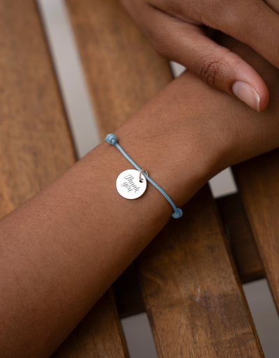 Bracelet en argent personnalisé avec médaille de 15mm sur un cordon bleu pastel. Une touche de sophistication pour votre look.