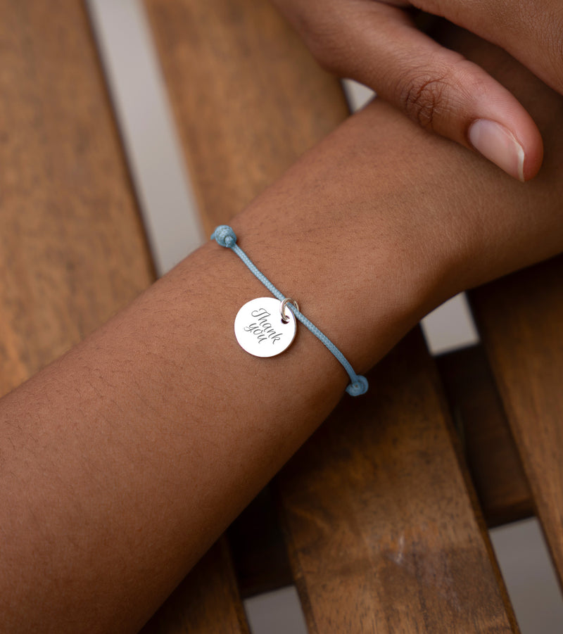 Bracelet en argent personnalisé avec médaille de 15mm sur un cordon bleu pastel. Une touche de sophistication pour votre look.