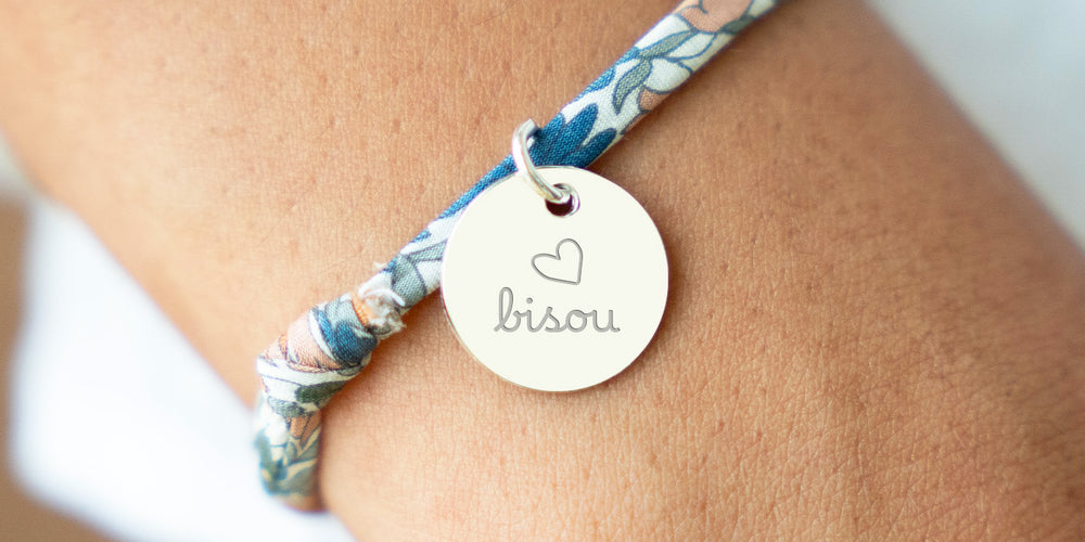 Un bracelet argenté avec une médaille de 15mm sur un lien Liberty lilas.