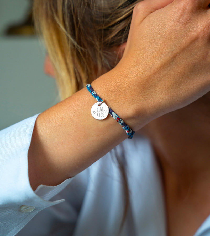 Bijou argenté composé d'une médaille de 15mm, attachée par un lien Liberty irisé.