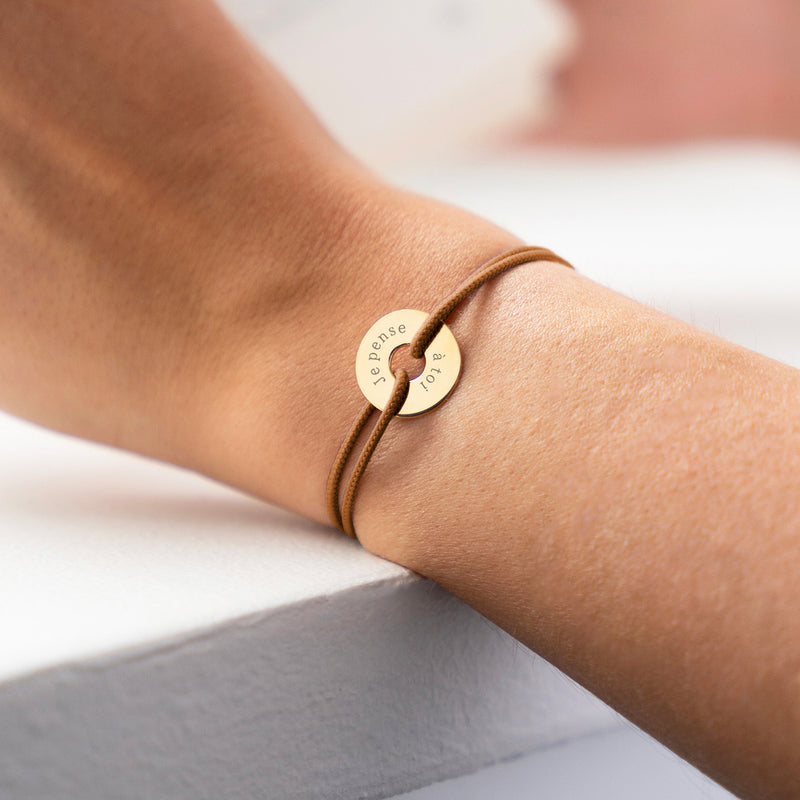 une forme cible, ce bracelet personnalisé en 15mm, plaqué or, est accompagné d'un cordon marron clair.