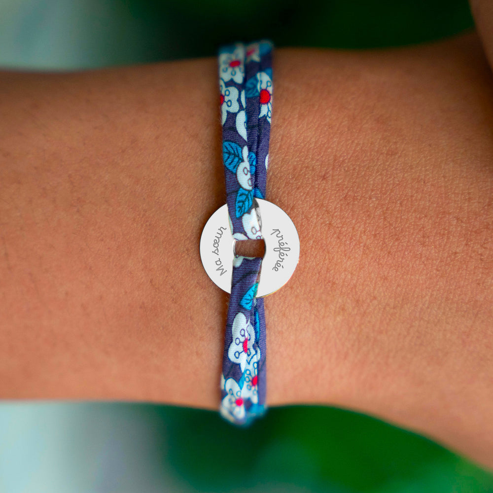 Le bracelet en cible, orné d'une médaille de 15mm en argent personnalisé, est délicatement rehaussé par un lien Liberty Iris.